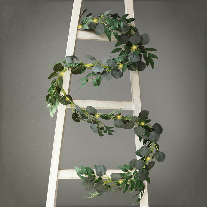 Eucalyptus garland draped on a wooden ladder.