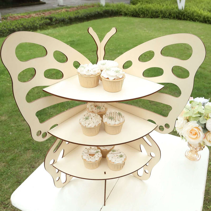 Butterfly-shaped cupcake stand displaying decorated cupcakes outdoors.