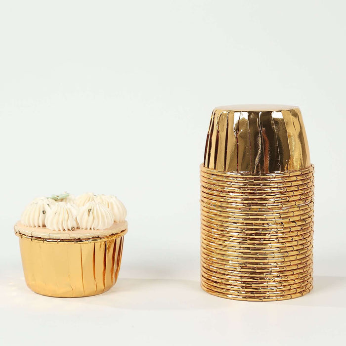 Gold cupcake liners and stacked cups on a white background
