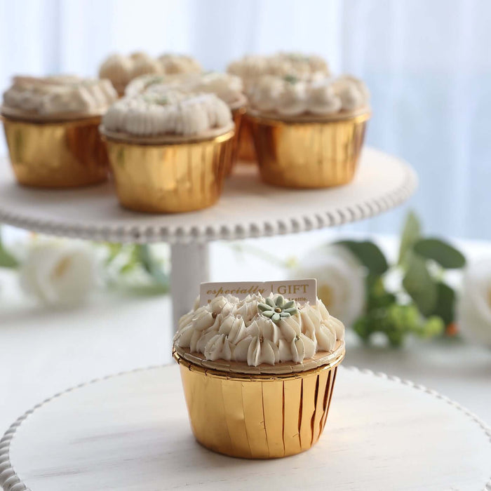 Golden cupcake with cream frosting on a decorative stand.