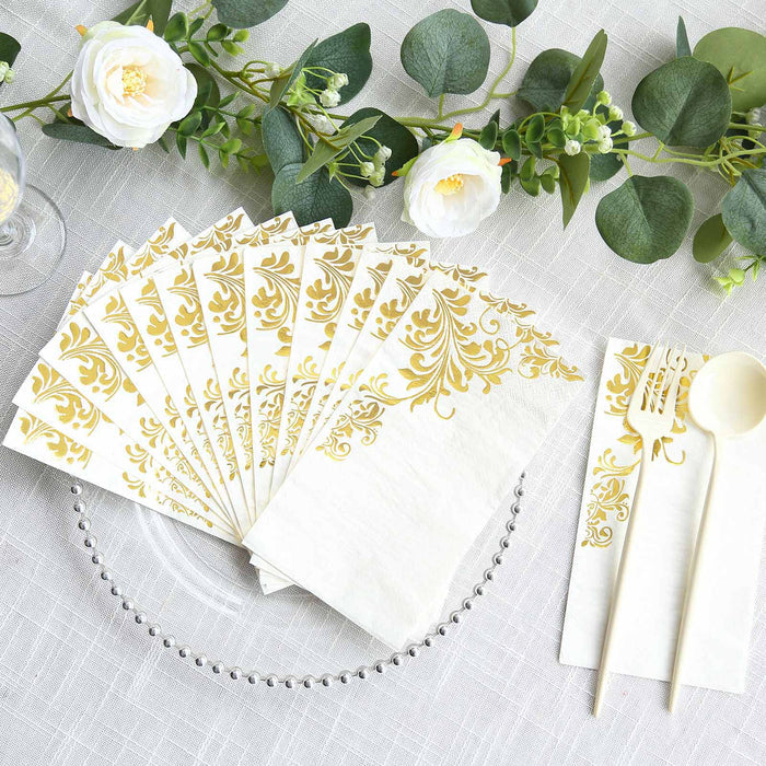 Gold-embellished paper napkins and utensils on a decorated table setting.